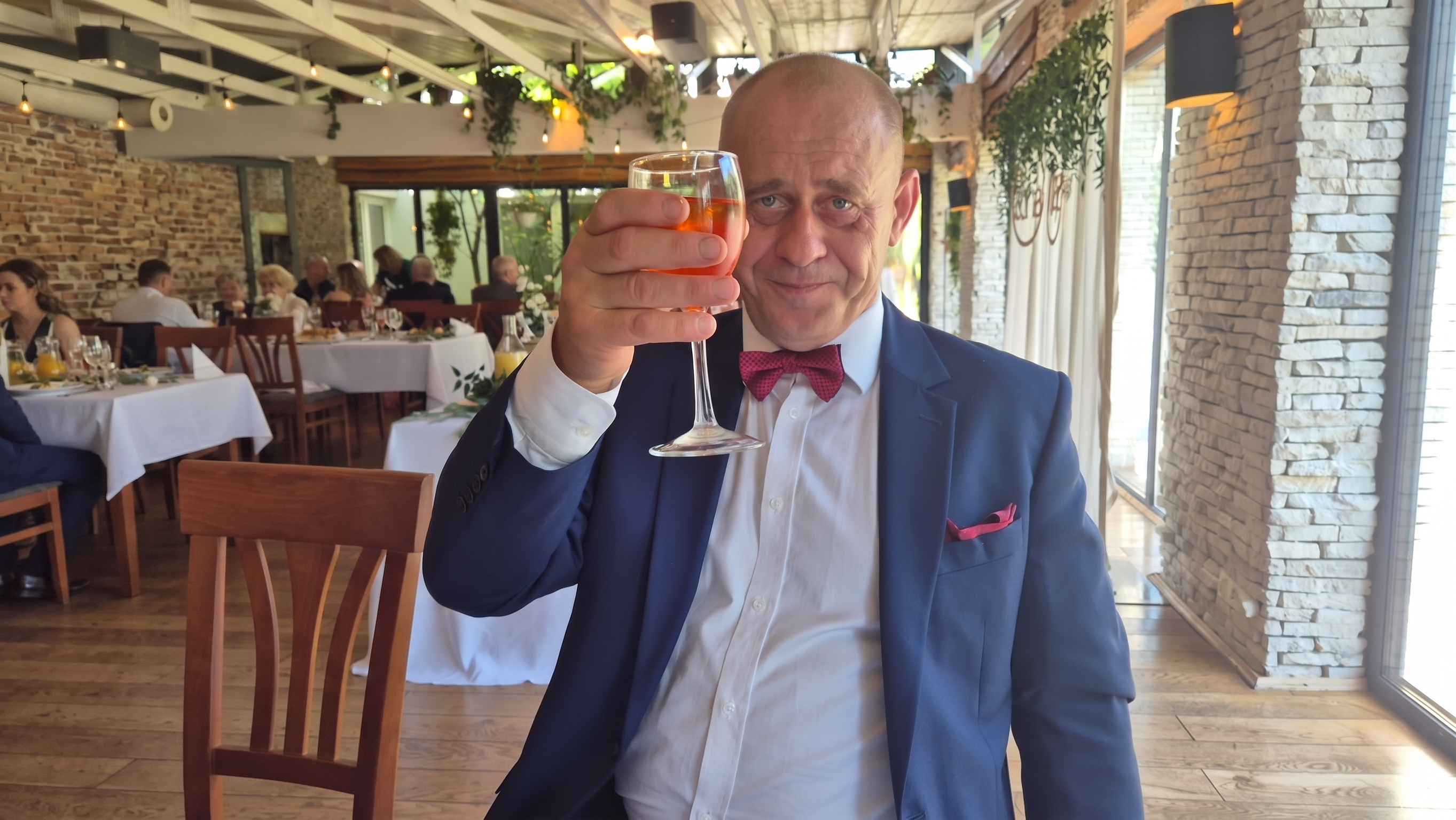 Gość wznosi toast kieliszkiem
